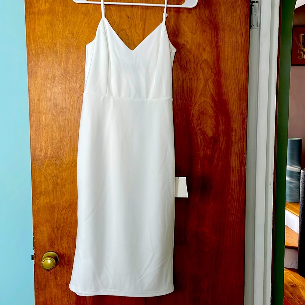 White spaghetti strap dress with bow details on the back.